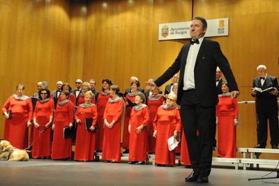 Coral Alaia, con su director en primer plano, recibiendo el aplauso del público en Burgos