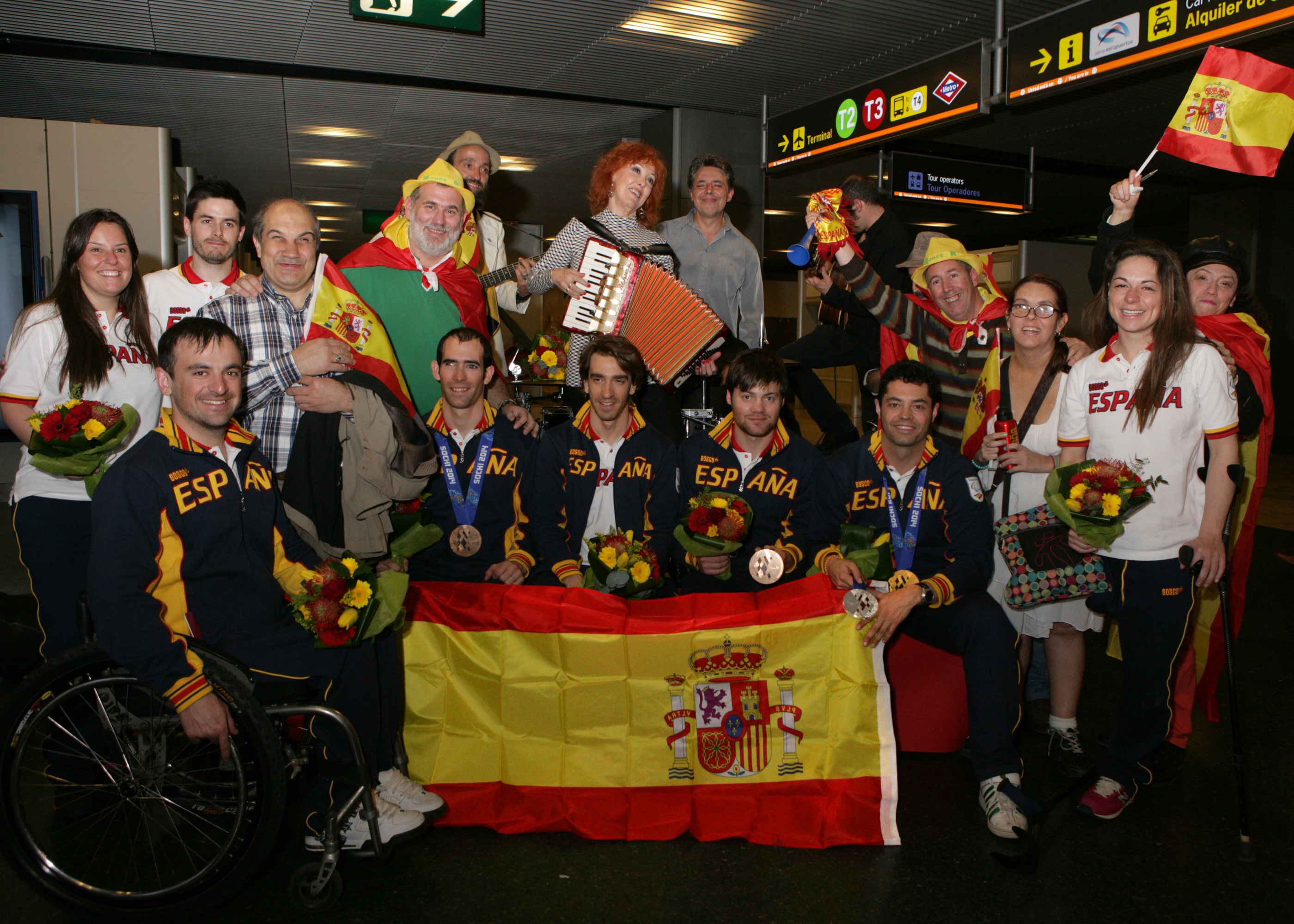 Aficionados y seguidores arropando a los deportistas a su llegada a Barajas