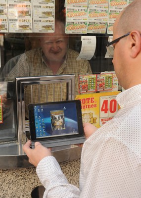 Un gestor comercial, utilizando su tablet, visita a un vendedor de la ONCE