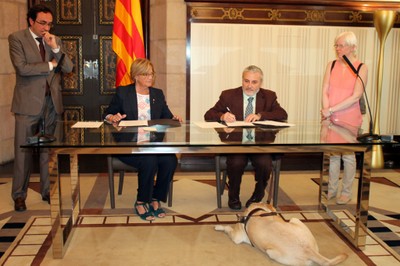 De izquierda a derecha: Nuria Gispert y Xavier Grau, rubricando el convenio entre el Parlament y la ONCE
