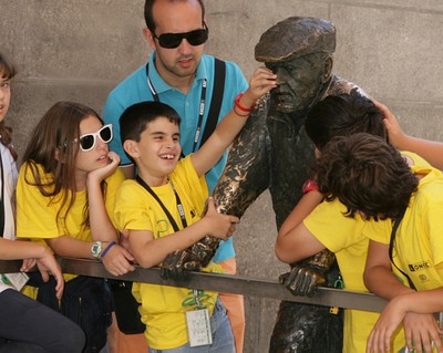 Tocando una escultura situada junto a la calle Bailén, frente a la Catedral de la  Almudena