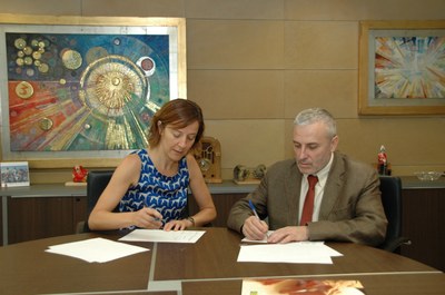 La directora editorial d’Ara Llibres, Izaskun Arretxe, firma junto al delegado territorial de la ONCE en Cataluñaa, Xavier Grau 
