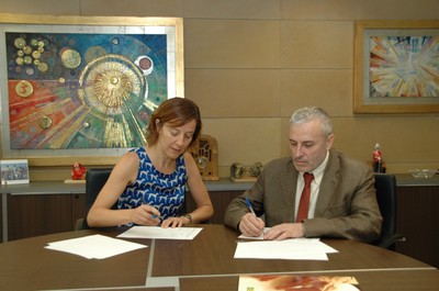 La directora editorial d’Ara Llibres, Izaskun Arretxe, firma junto al delegado territorial de la ONCE en Cataluñaa, Xavier Grau 
