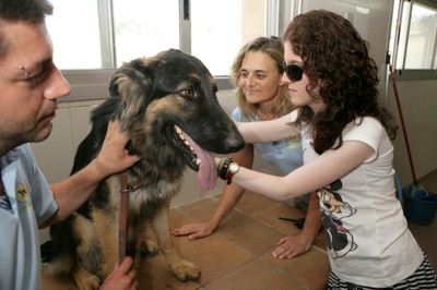 Lucía Tabernero acaricia un perro guía durante la visita a la Escuela de la Fundación ONCE del Perro Guía