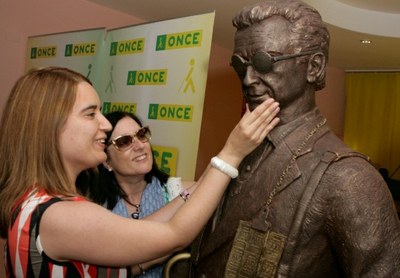 la presidenta de la ONCE en Madrid, Leonor Pérez, reconoce al tacto el rostro de la escultura