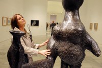 Una afiliada toca una escultura en una de las visitas guiadas al Museo Reina Sofía