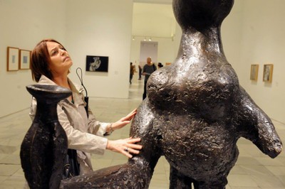 Una afiliada toca una escultura en una de las visitas guiadas al Museo Reina Sofía