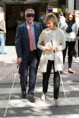 El consejero de Políticas Sociales madrileño, Carlos Izquierdo, cruza una calle 'a ciegas' acompañado por una técnico de rehabilitación de la ONCE
