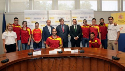 González Serna, Cardenal y Carballeda (en el centro), flanqueados por el grupo de deportistas paralímpicos, tras la firma del convenio