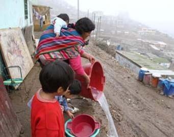Una madre con sus hijos en una zona chabolista de una región andina