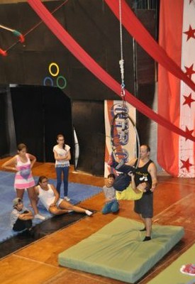 Uno de los pequeños intenta colgarse con sus piernas de un aro volador 