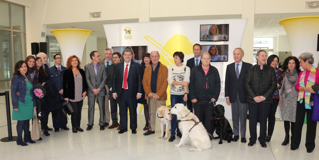 Autoridades, representantes de la ONCE y de la FOPG y usuarios de perros guía en la inauguración de la expo en Bilbao