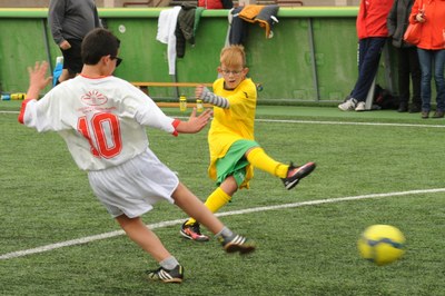 Un pequeño con discapacidad visual, chutando a puerta durante uno de los partidos de fútbol disputados