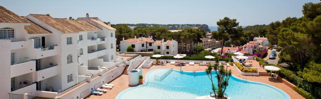 Vista aérea de la piscina y apartamentos del ILUNION Menorca
