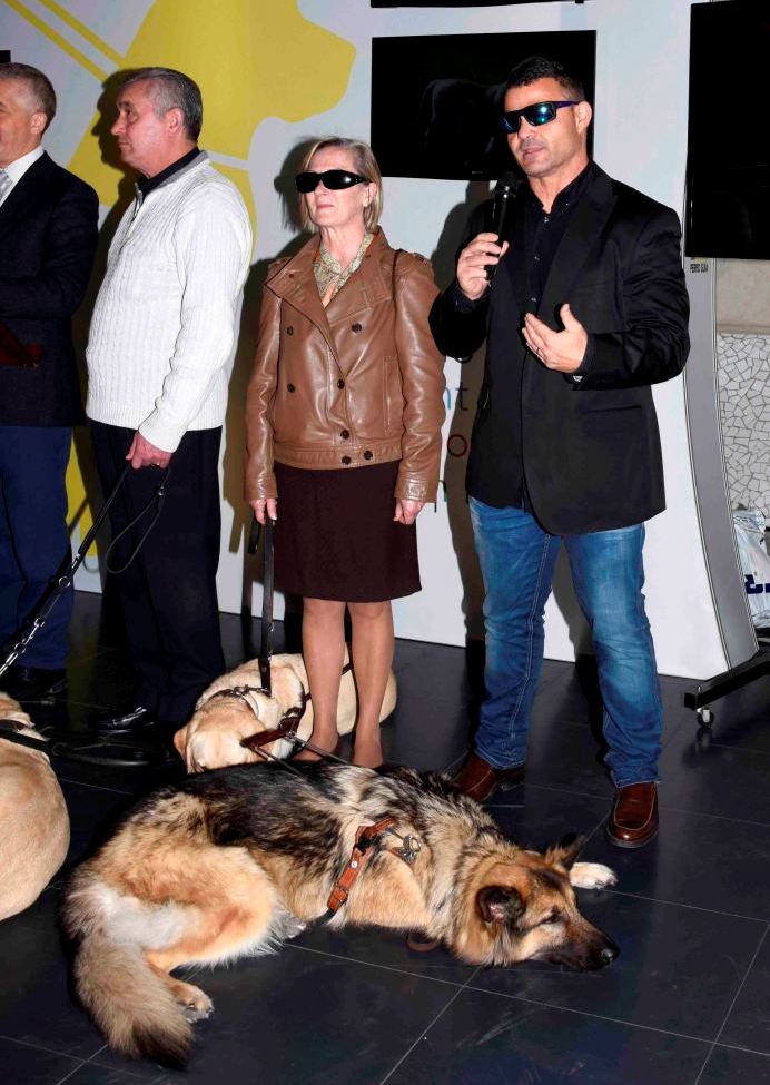 El atleta paralímpico David Casinos, junto a su perro guía y otros usuarios valencianos, se dirige al público durante la presentación de la exposición en la capital del Turia