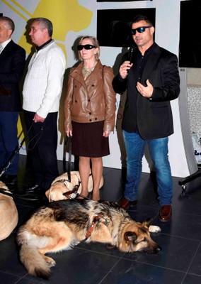 El atleta paralímpico David Casinos, junto a su perro guía y otros usuarios valencianos, se dirige al público durante la presentación de la exposición en la capital del Turia