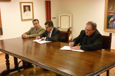Monseñor Gil Tamayo (a la izquierda) y Martínez Donoso suscriben el acuerdo, en presencia de Ignacio Tremiño