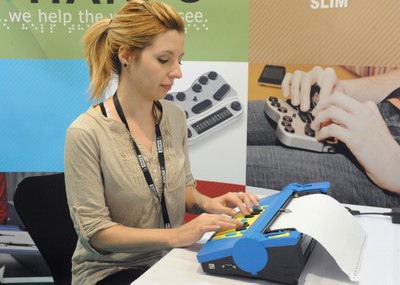 Una joven escribe con un moderno terminal informático braille  