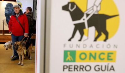 Usuarios de perro guía a la entrada de la exposición instalada en el Zoo de Barcelona