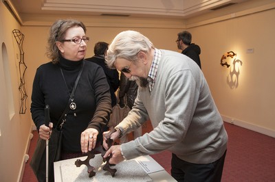 Dos visitantes observan al tacto una obra de Canogar
