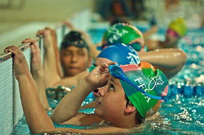 Un grupo de niños con discapacidad arrancan en una prueba de natación