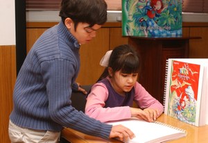 Un niño y una niña afiliados consultan un texto braille en el aula