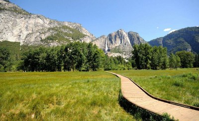 Un paisaje de montaña con una senda adaptada mediante plataforma de madera