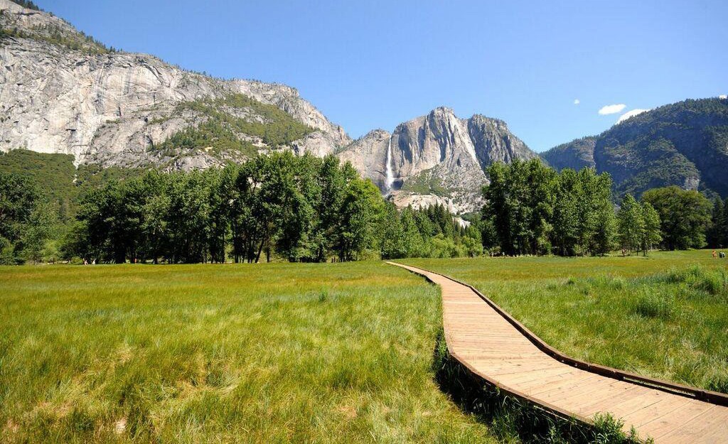 Un paisaje de montaña con una senda adaptada mediante plataforma de madera