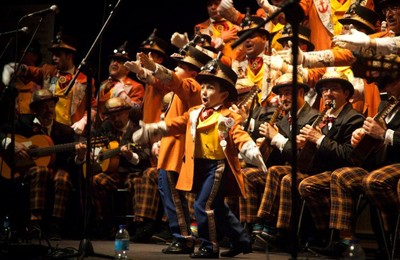 Un pequeño partcipante en la comparsa ganadora del tercer premio actuando en primer plano sobre el escenario