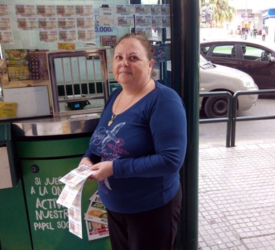 María Ángeles García posa delante de su quiosco de venta de los productos de juego de la ONCE, en Málaga