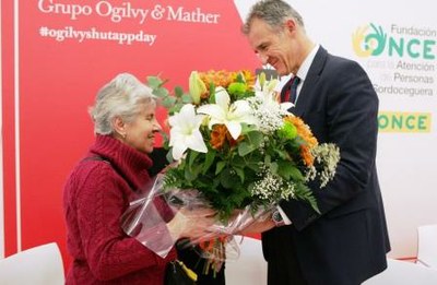 Conchi, persona sordociega, recoge un ramo de flores de manos del consejero delegado de Ogilby, Jesús Valderrábano