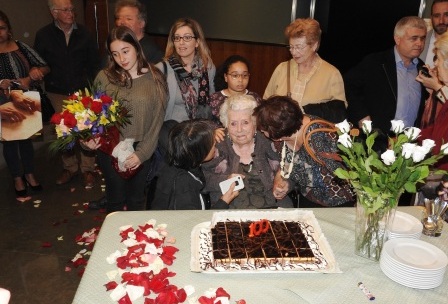 La homenajeada, rodeada por su familia, ante la tarta conmemorativa
