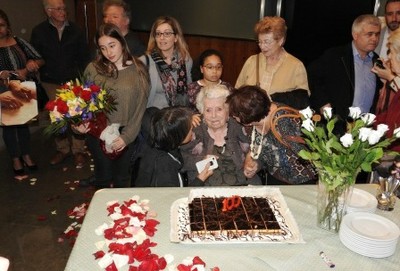 La homenajeada, rodeada por su familia, ante la tarta conmemorativa