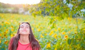 Elena, en el campo, rodeada de flores, en una foto personal