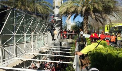 Un gran número de transeúntes y curiosos se paran a observar el salvamento mediante poleas de una persona con su perro guía