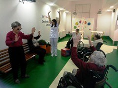 Un grupo de residentes practica ejercicios físicos dirigidas por una monitora