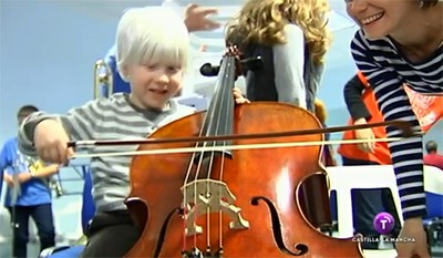 Un niño con discapacidad visual intenta sacar acordes de un bajo
