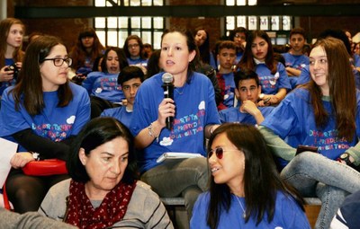 Unas jóvenes participantes intervienen, micrófono en mano, en el debate con los ponentes