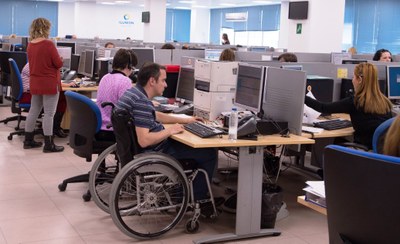 Operarios del Contact Center, uno de ellos en silla de ruedas, en plena actividad