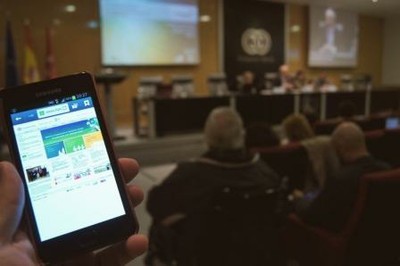 Una persona ciega utiliza en su móvil una aplicación accesible, en el transcurso de un acto público