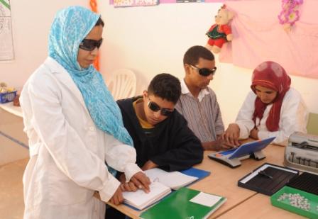 Dos profesoras de los campamento enseñan a otros tantos alumnos lectura braille y manejo del ordenador