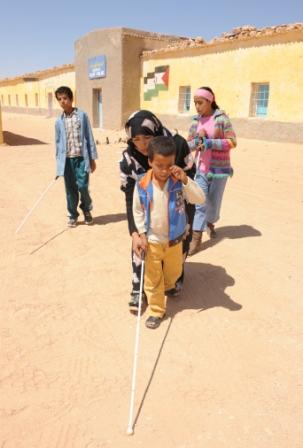 Niños ciegos son instruidos en el manejo del bastón blanco en uno de los campamentos de refugiados