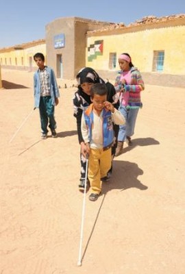 Niños ciegos son instruidos en el manejo del bastón blanco en uno de los campamentos de refugiados