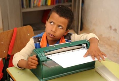 Un niño ciego de los campamentos repasa un texto que ha escrito en una de las máquinas Perkins cedidas por la ONCE