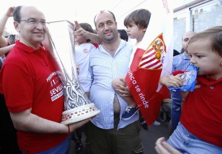 El presidente Castro se fotografía con un aficionado que porta en brazos a su hijo provisto de una bandera sevillista