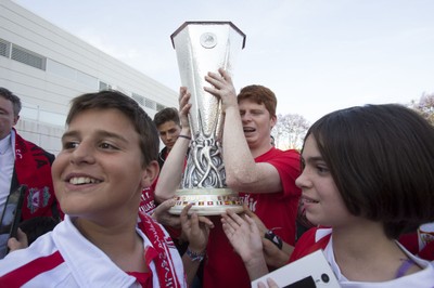 Un joven afiliado levanta emocionado el trofeo rodeado por sus compañeros