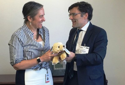 Alberto Durán entrega un peluche/mascota de perro guía a Julie T. Katzman
