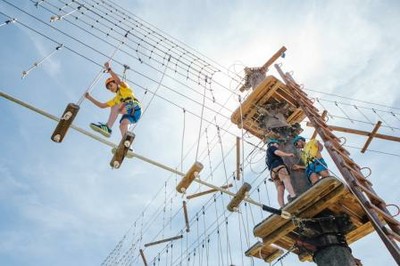 Cruzando un puente de cuerdas en una práctica de juegos de aventura