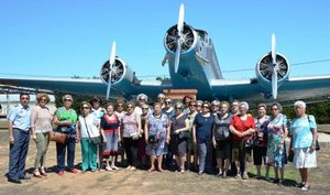 El grupo de mayores posa, junto a un avión militar, en su visita a la base de Alcantarilla