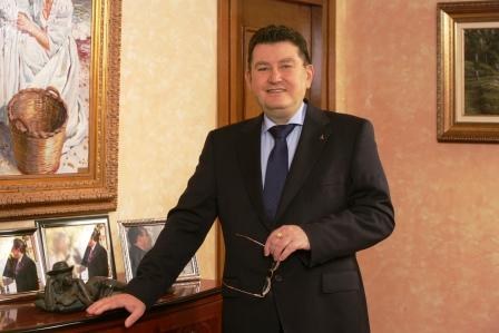 El director general, de pie, en su despacho